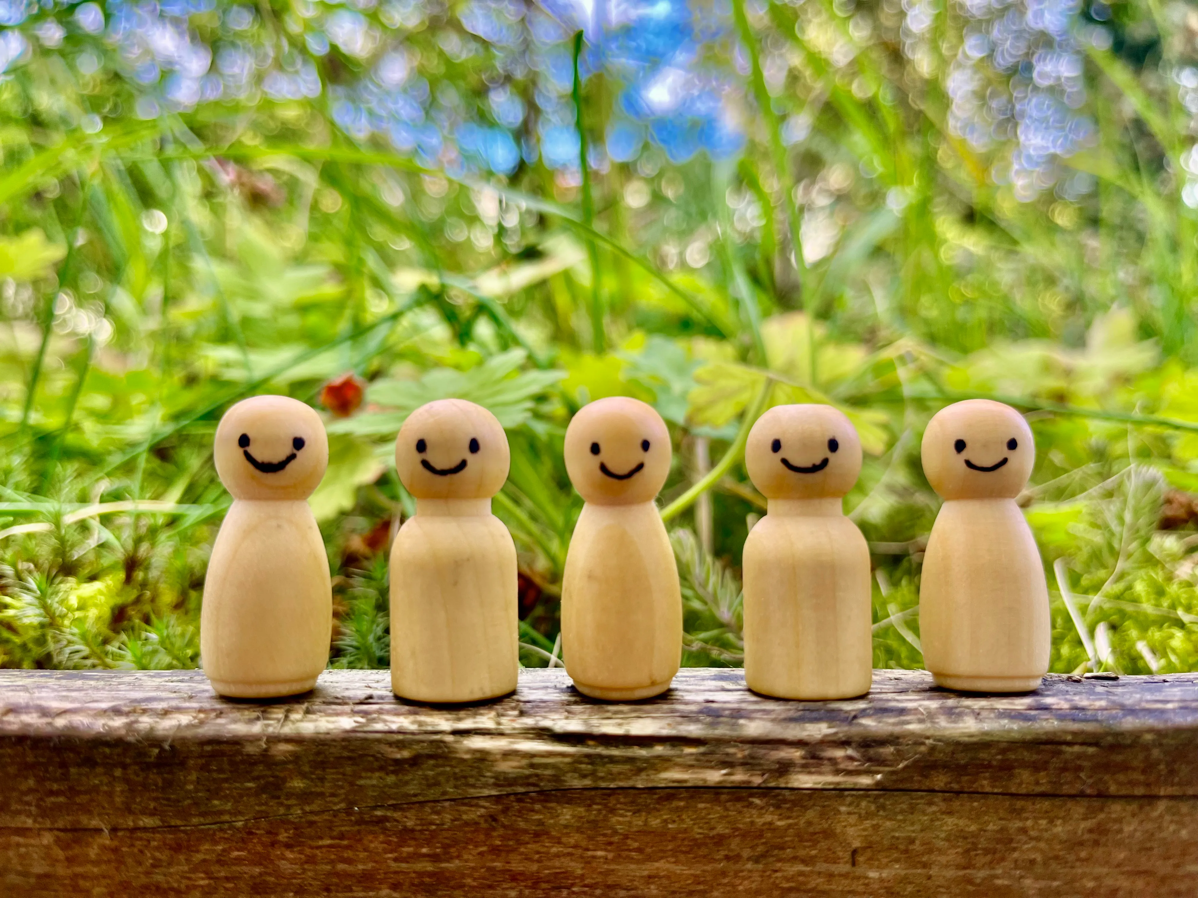 Lächelnde Aufstellungsfiguren aus Holz auf einem Baumstamm